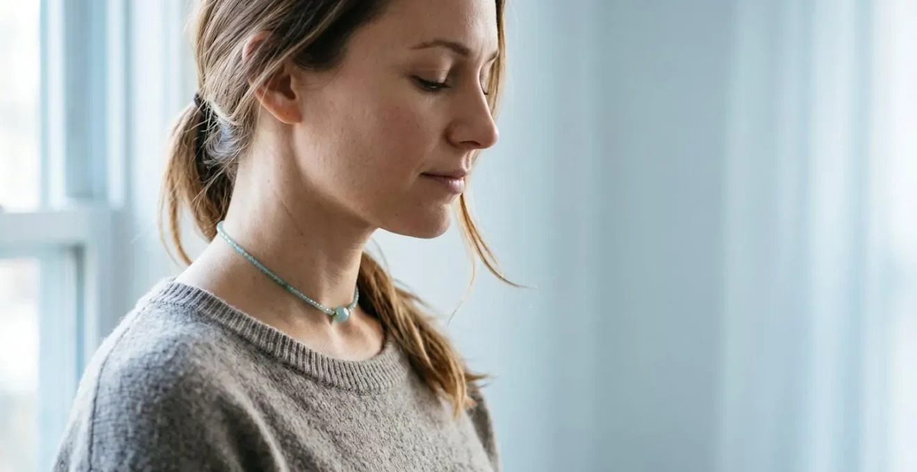Femme sereine portant un collier ras-du-cou en aigue-marine dans une ambiance apaisante