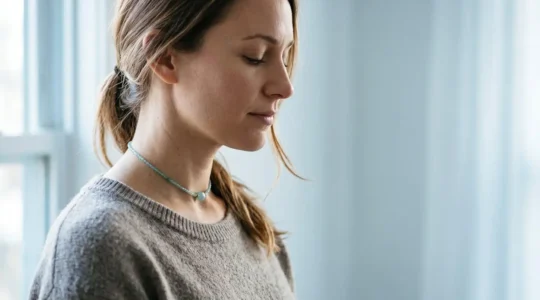Femme sereine portant un collier ras-du-cou en aigue-marine dans une ambiance apaisante